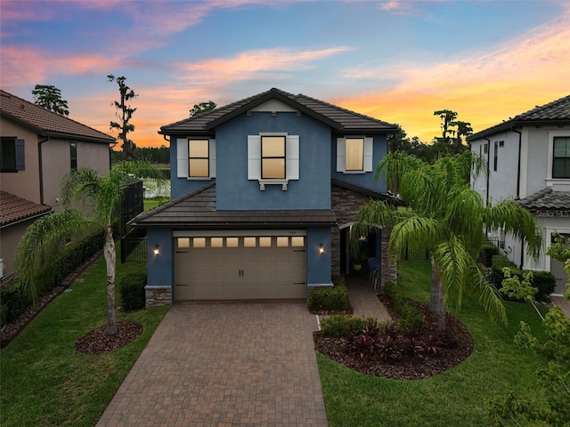 19191 Pease Pl, Lutz, FL 33558 - traditional-style home featuring stucco siding, decorative driveway, an attached garage, a tile roof, and stone siding