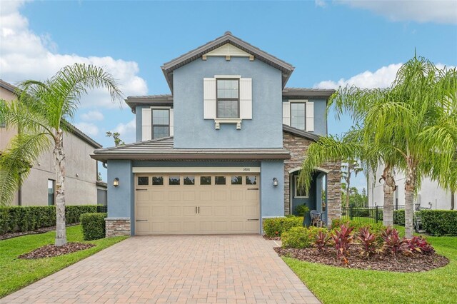 19191 Pease Pl, Lutz, FL 33558 - view of front of home featuring stucco siding, an attached garage, stone siding, and decorative driveway