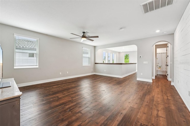 19191 Pease Pl, Lutz, FL 33558 - unfurnished living room with a ceiling fan, dark wood-style flooring, arched walkways, baseboards, and recessed lighting