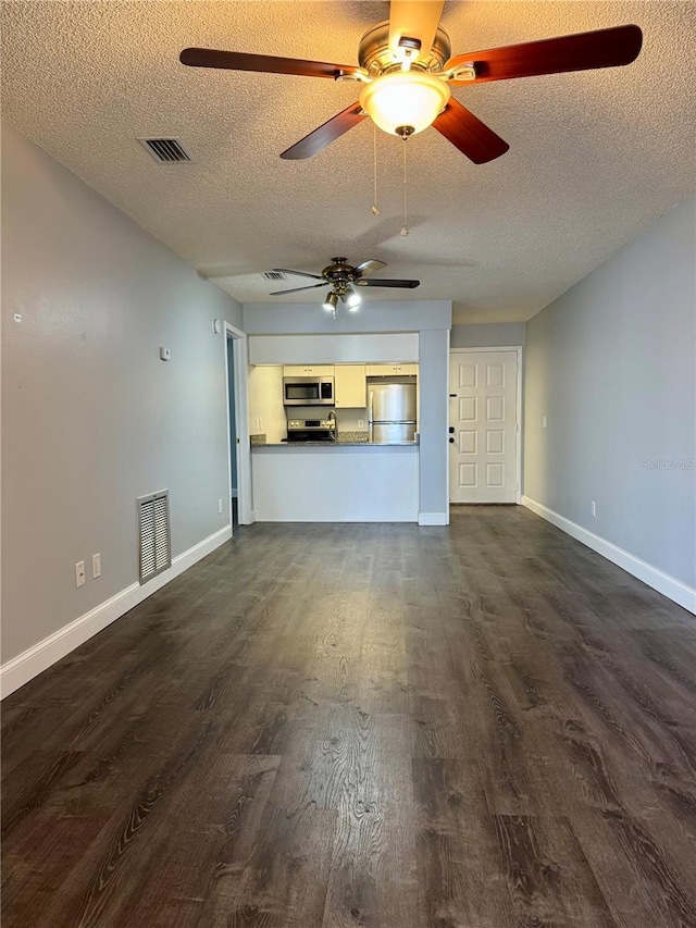 3802 N Oak Dr Unit W22, Tampa, FL 33611 - unfurnished living room featuring ceiling fan, a textured ceiling, dark wood-type flooring, and baseboards