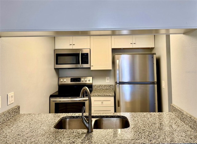 3802 N Oak Dr Unit W22, Tampa, FL 33611 - kitchen with stainless steel appliances, light stone counters, a sink, and white cabinets