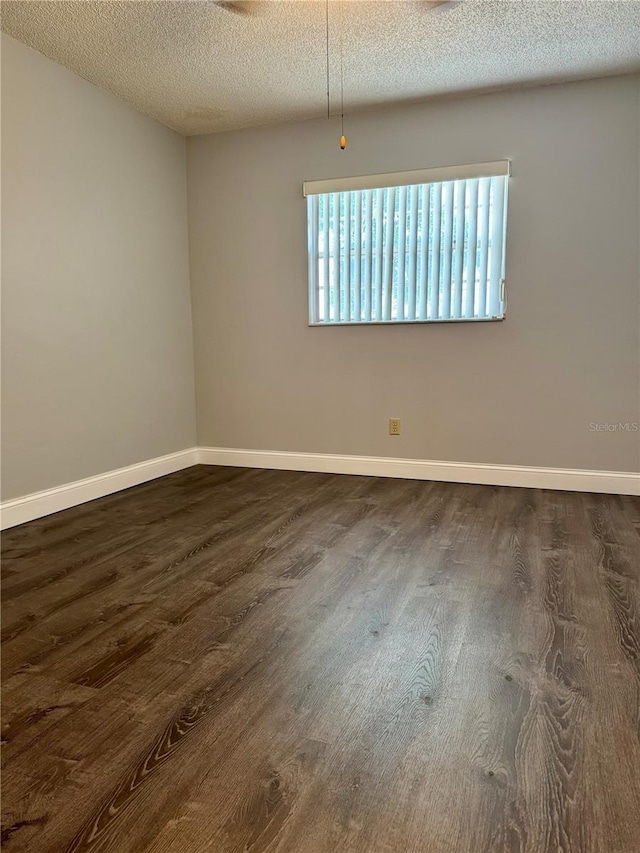 3802 N Oak Dr Unit W22, Tampa, FL 33611 - empty room featuring dark wood-style floors, a textured ceiling, and baseboards