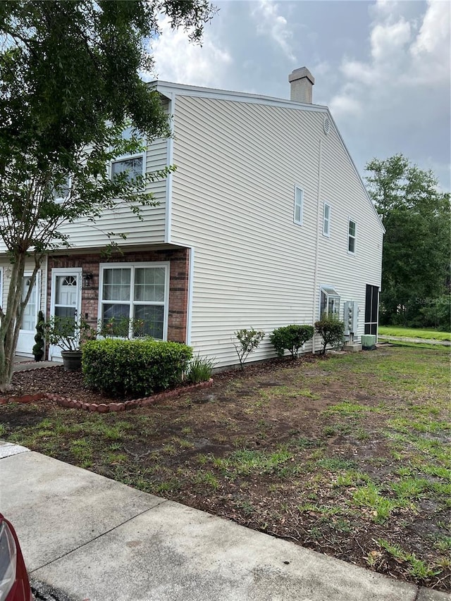 7616 Colonial Ct, Tampa, FL 33615 - view of side of property with a chimney