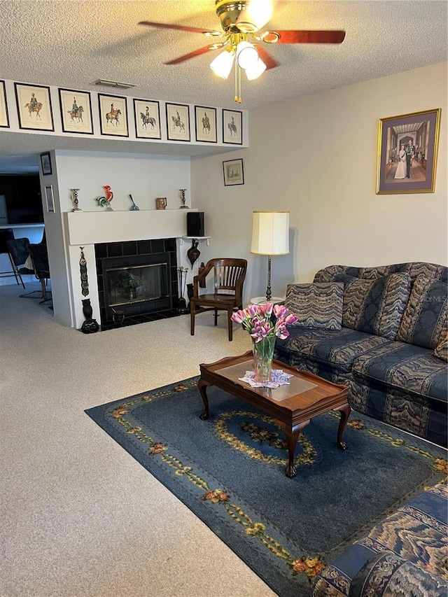 7616 Colonial Ct, Tampa, FL 33615 - carpeted living area featuring ceiling fan, a textured ceiling, and a tiled fireplace