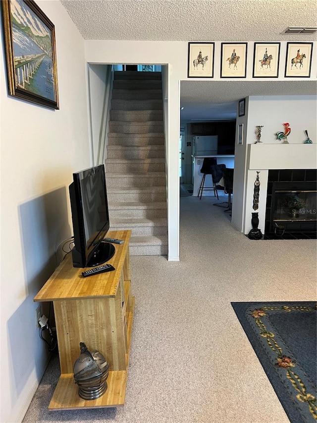 7616 Colonial Ct, Tampa, FL 33615 - carpeted living area with a textured ceiling, stairway, and a fireplace