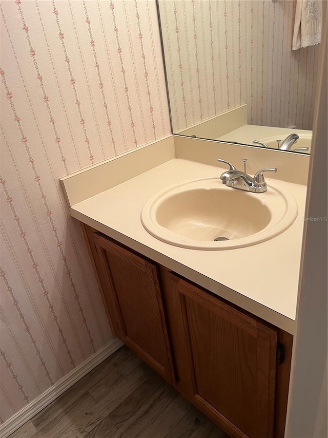 7616 Colonial Ct, Tampa, FL 33615 - bathroom with vanity, wood finished floors, and wallpapered walls