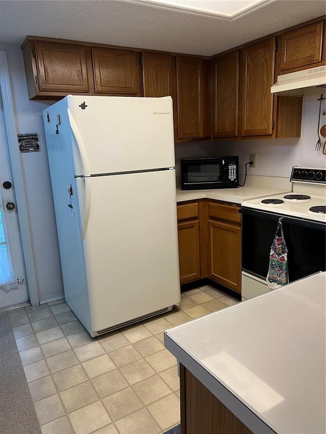 7616 Colonial Ct, Tampa, FL 33615 - kitchen with freestanding refrigerator, electric range oven, under cabinet range hood, black microwave, and light countertops