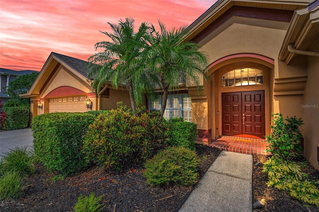 4133 Auston Way, Palm Harbor, FL 34685 - exterior entry at dusk with stucco siding and a garage