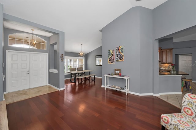 4133 Auston Way, Palm Harbor, FL 34685 - entrance foyer featuring wood finished floors, a chandelier, high vaulted ceiling, and baseboards