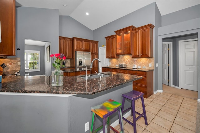 4133 Auston Way, Palm Harbor, FL 34685 - kitchen with stainless steel refrigerator with ice dispenser, a sink, a peninsula, dark stone countertops, and brown cabinets
