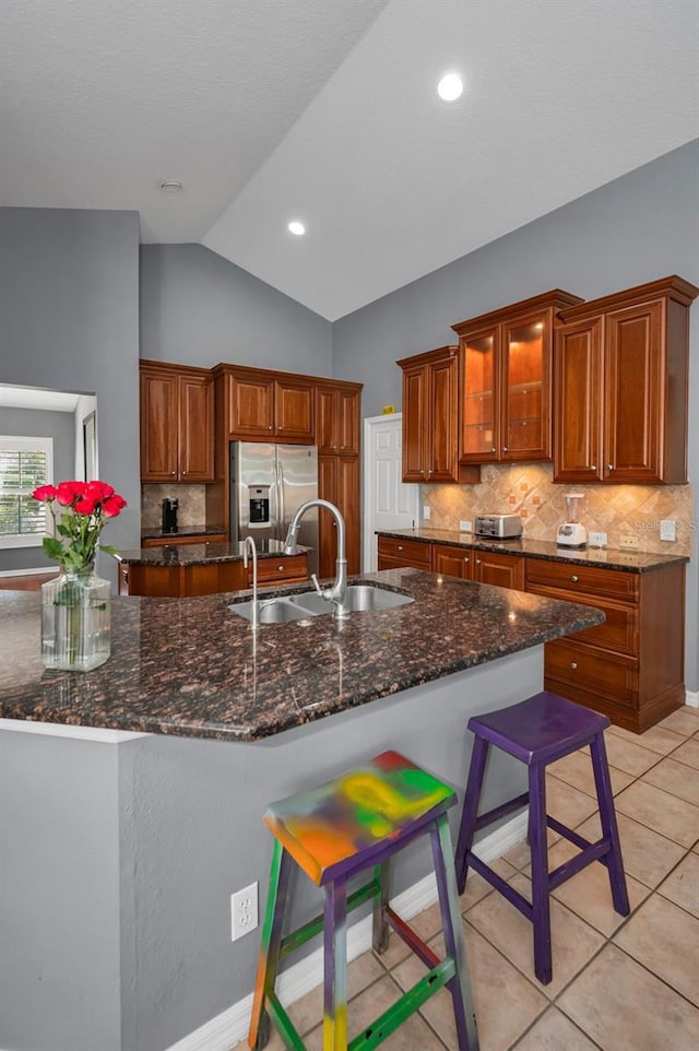 4133 Auston Way, Palm Harbor, FL 34685 - kitchen with a sink, stainless steel fridge with ice dispenser, decorative backsplash, vaulted ceiling, and a kitchen island with sink