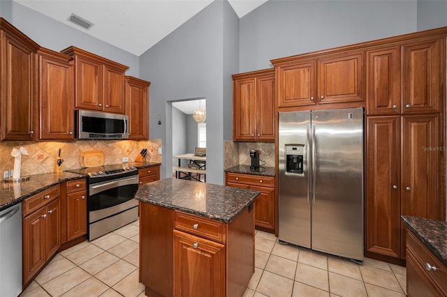 4133 Auston Way, Palm Harbor, FL 34685 - kitchen with appliances with stainless steel finishes, decorative backsplash, brown cabinets, light tile patterned floors, and high vaulted ceiling