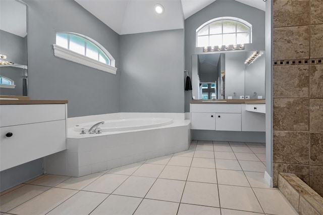 4133 Auston Way, Palm Harbor, FL 34685 - bathroom with vaulted ceiling, vanity, a garden tub, and tile patterned flooring