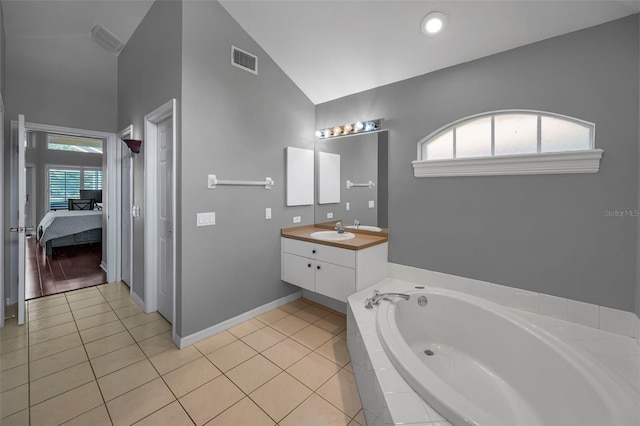4133 Auston Way, Palm Harbor, FL 34685 - ensuite bathroom featuring a bath, vanity, tile patterned floors, baseboards, and high vaulted ceiling