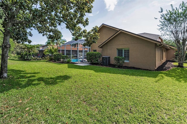 4133 Auston Way, Palm Harbor, FL 34685 - rear view of house with central AC, stucco siding, a yard, and glass enclosure