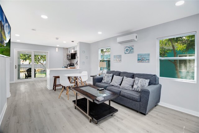 13325 1st St E, Madeira Beach, FL 33708 - living area featuring a wall mounted AC, light wood finished floors, healthy amount of natural light, baseboards, and recessed lighting