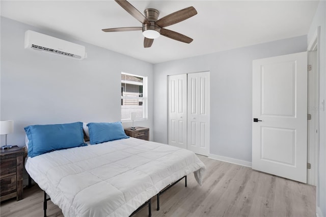 13325 1st St E, Madeira Beach, FL 33708 - bedroom featuring a wall mounted air conditioner, a closet, light wood-style floors, a ceiling fan, and baseboards