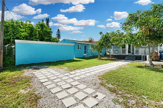 13325 1st St E, Madeira Beach, FL 33708 - view of grassy yard with covered porch and central AC