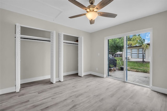24862 US Highway 19 N Unit 1105, Clearwater, FL 33763 - unfurnished bedroom with access to outside, two closets, wood finished floors, and baseboards