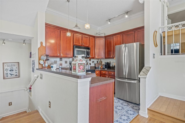 741 Mainsail Dr, Tampa, FL 33602 - kitchen featuring stainless steel appliances, rail lighting, a peninsula, light wood-style floors, and a textured ceiling