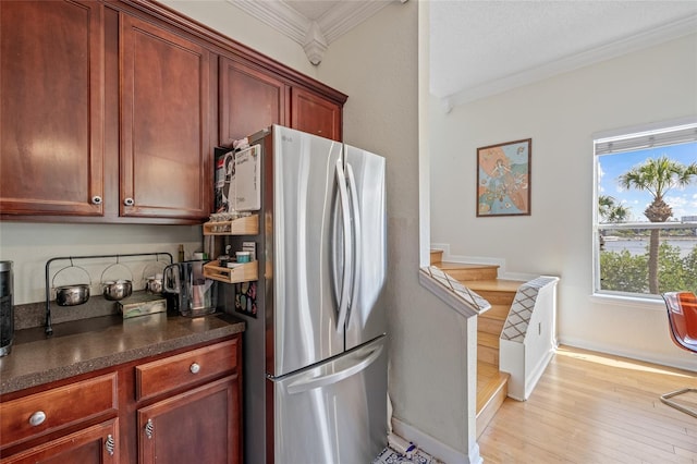 741 Mainsail Dr, Tampa, FL 33602 - kitchen featuring freestanding refrigerator, crown molding, dark countertops, light wood-style floors, and baseboards