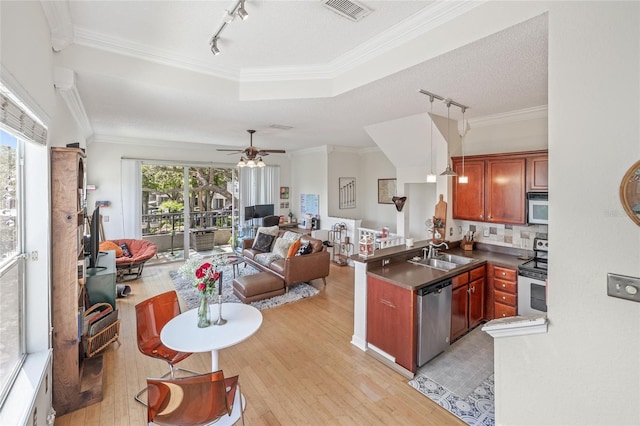 741 Mainsail Dr, Tampa, FL 33602 - kitchen featuring stainless steel appliances, rail lighting, light wood finished floors, a sink, and open floor plan