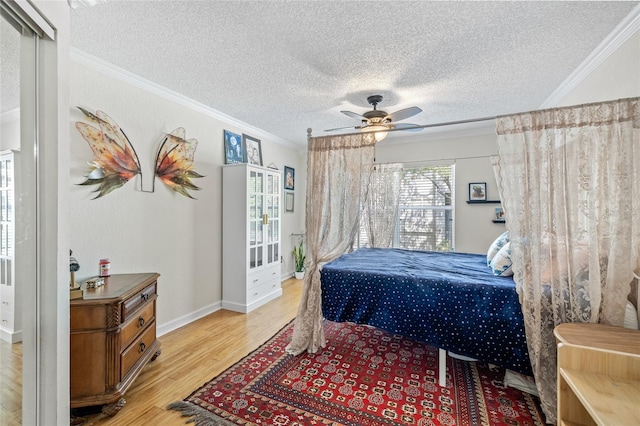 741 Mainsail Dr, Tampa, FL 33602 - bedroom with crown molding, light wood-style floors, a textured ceiling, a ceiling fan, and baseboards