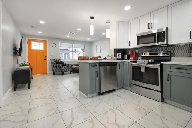 13800 Judy Ave, Hudson, FL 34667 - kitchen with stainless steel appliances, gray cabinetry, a peninsula, light countertops, and recessed lighting