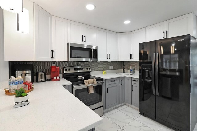 13800 Judy Ave, Hudson, FL 34667 - kitchen with appliances with stainless steel finishes, white cabinets, light marble finish flooring, tasteful backsplash, and recessed lighting