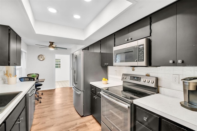 2608 Camille Dr, Palm Harbor, FL 34684 - kitchen with appliances with stainless steel finishes, dark cabinetry, light wood-style flooring, light countertops, and recessed lighting