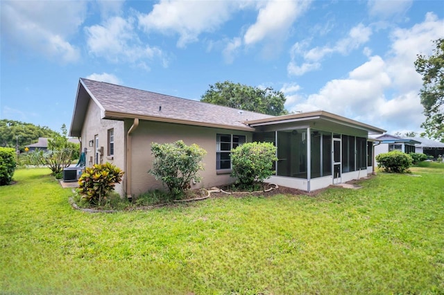 2608 Camille Dr, Palm Harbor, FL 34684 - rear view of house with a sunroom, a lawn, stucco siding, and cooling unit