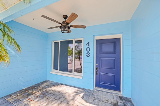 403 Normandy Rd, Madeira Beach, FL 33708 - view of exterior entry featuring ceiling fan and concrete block siding