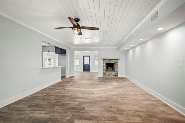 403 Normandy Rd, Madeira Beach, FL 33708 - unfurnished living room featuring ornamental molding, wood ceiling, a ceiling fan, wood finished floors, and a stone fireplace
