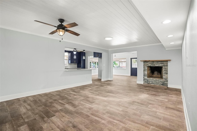 403 Normandy Rd, Madeira Beach, FL 33708 - unfurnished living room with ceiling fan, ornamental molding, baseboards, a fireplace, and wood finished floors