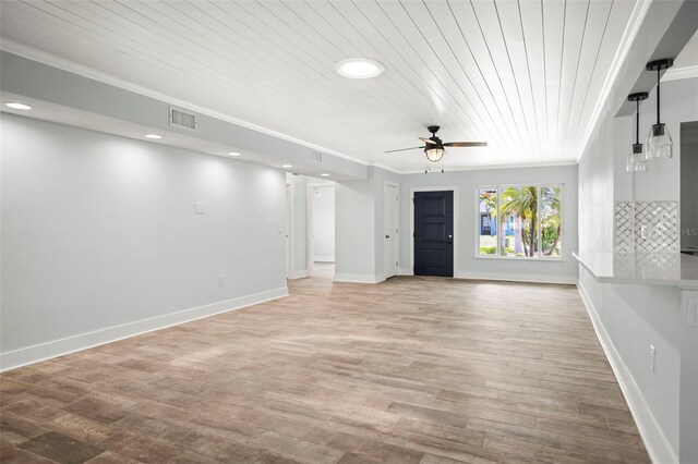 403 Normandy Rd, Madeira Beach, FL 33708 - unfurnished living room featuring wood ceiling, a ceiling fan, ornamental molding, light wood finished floors, and baseboards