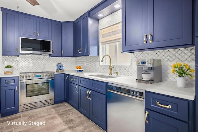 403 Normandy Rd, Madeira Beach, FL 33708 - kitchen featuring stainless steel appliances, a sink, light countertops, and blue cabinetry