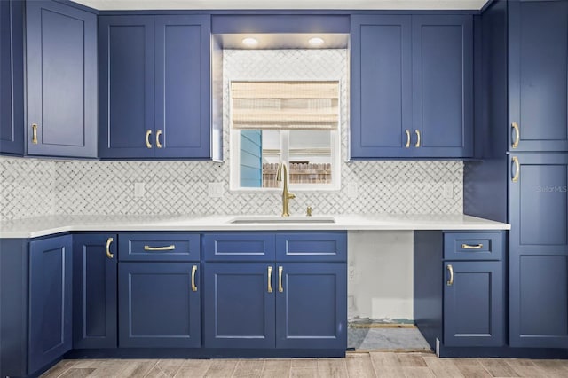 403 Normandy Rd, Madeira Beach, FL 33708 - kitchen with a sink, light countertops, blue cabinetry, and wood tiled floors