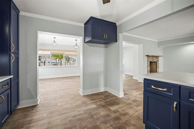 403 Normandy Rd, Madeira Beach, FL 33708 - kitchen with blue cabinetry, light countertops, baseboards, crown molding, and dark wood finished floors