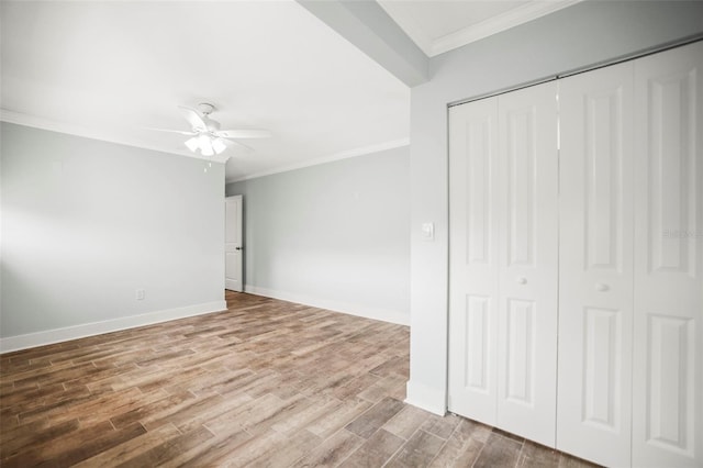 403 Normandy Rd, Madeira Beach, FL 33708 - unfurnished bedroom featuring crown molding, wood finished floors, baseboards, a closet, and a ceiling fan