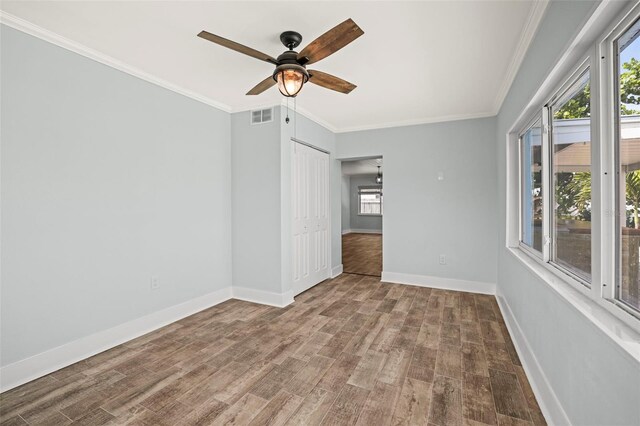 403 Normandy Rd, Madeira Beach, FL 33708 - spare room with wood finished floors, crown molding, a ceiling fan, and baseboards