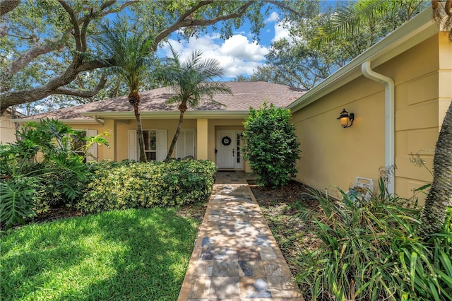 8127 Siquita Dr NE, Saint Petersburg, FL 33702 - view of front of home featuring stucco siding, a front yard, and roof with shingles