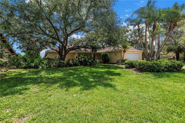 8127 Siquita Dr NE, Saint Petersburg, FL 33702 - view of front of property featuring an attached garage, stucco siding, and a front lawn