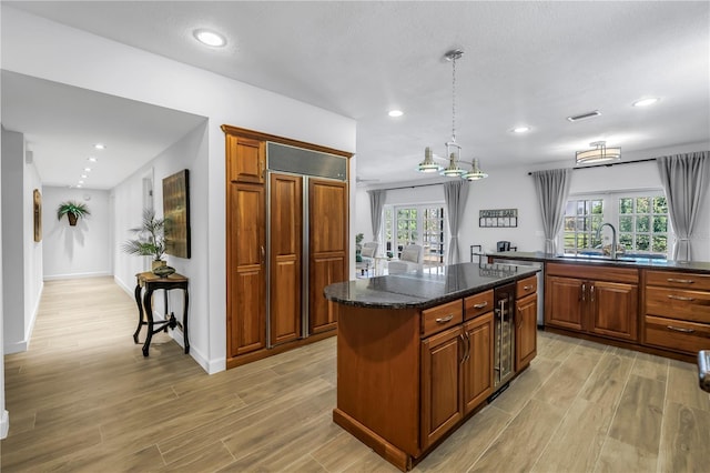 8127 Siquita Dr NE, Saint Petersburg, FL 33702 - kitchen featuring light wood-type flooring, a kitchen island, a sink, plenty of natural light, and recessed lighting