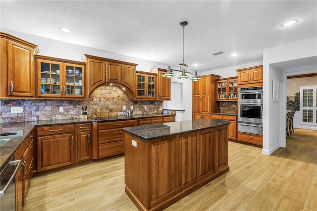 8127 Siquita Dr NE, Saint Petersburg, FL 33702 - kitchen featuring brown cabinets, stainless steel appliances, a center island, a warming drawer, and recessed lighting