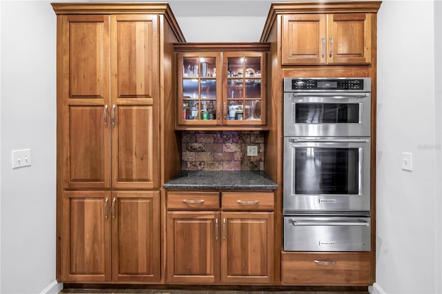 8127 Siquita Dr NE, Saint Petersburg, FL 33702 - kitchen with a warming drawer, double oven, brown cabinetry, and baseboards