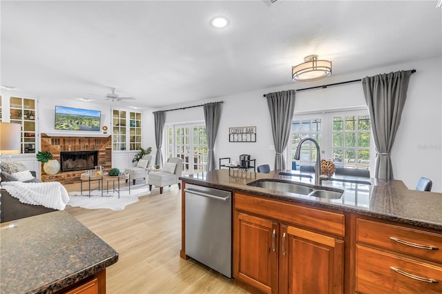 8127 Siquita Dr NE, Saint Petersburg, FL 33702 - kitchen featuring dishwasher, a sink, light wood finished floors, a ceiling fan, and dark stone counters