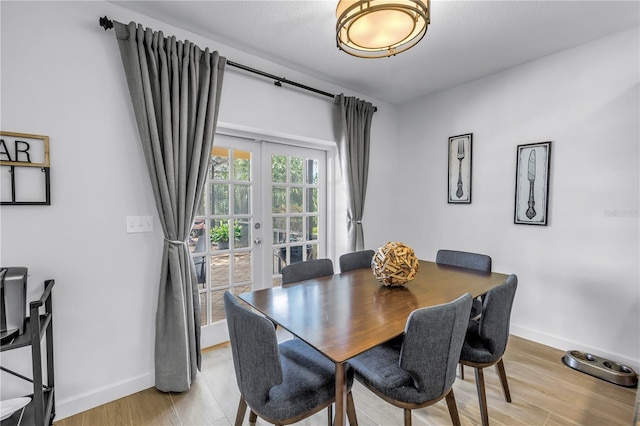 8127 Siquita Dr NE, Saint Petersburg, FL 33702 - dining area with french doors, baseboards, and light wood-style floors