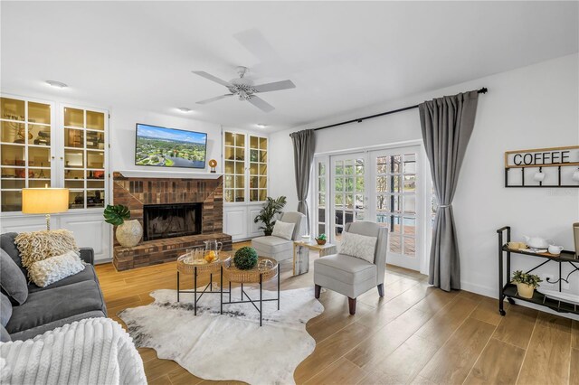 8127 Siquita Dr NE, Saint Petersburg, FL 33702 - living area with wood finished floors, a ceiling fan, and a fireplace