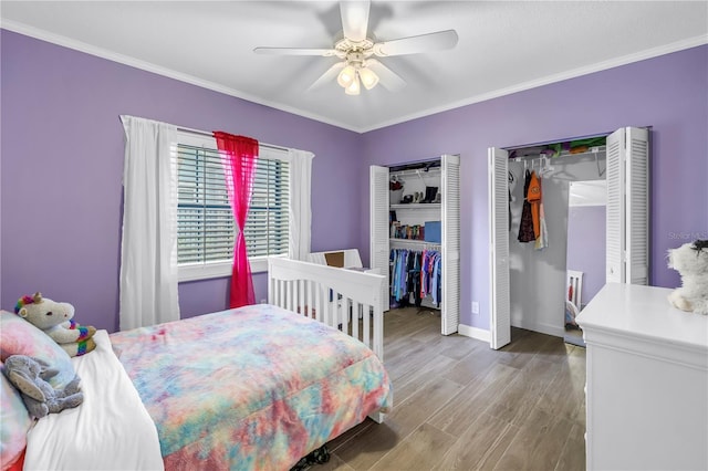 8127 Siquita Dr NE, Saint Petersburg, FL 33702 - bedroom with two closets, crown molding, baseboards, wood finished floors, and a ceiling fan