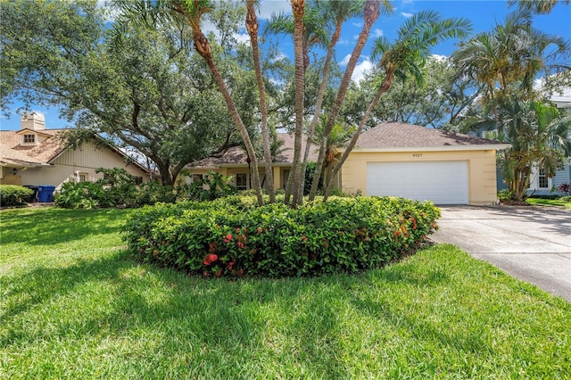 8127 Siquita Dr NE, Saint Petersburg, FL 33702 - obstructed view of property with concrete driveway, an attached garage, a front yard, and stucco siding